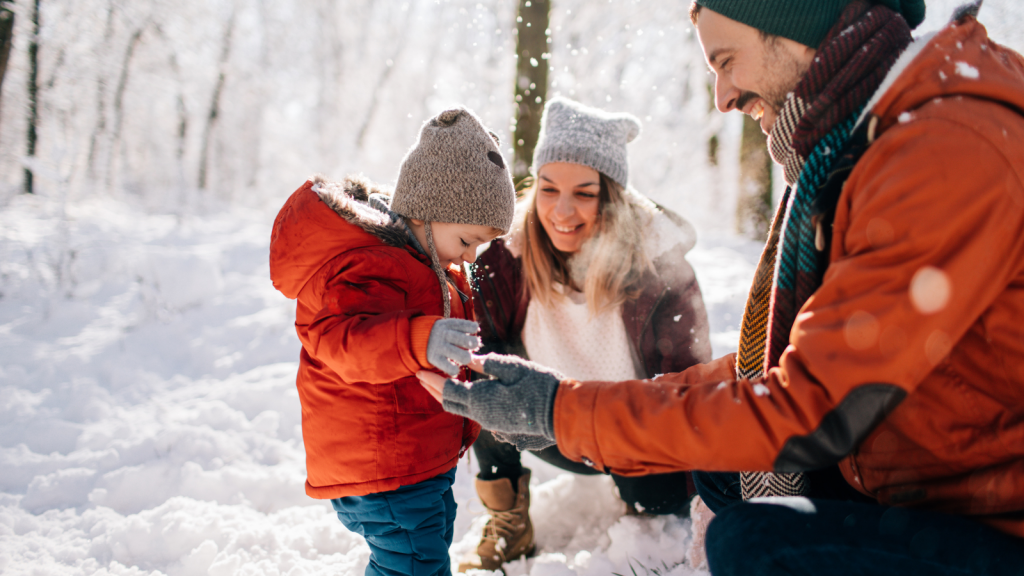 Parents playing in snow with their child