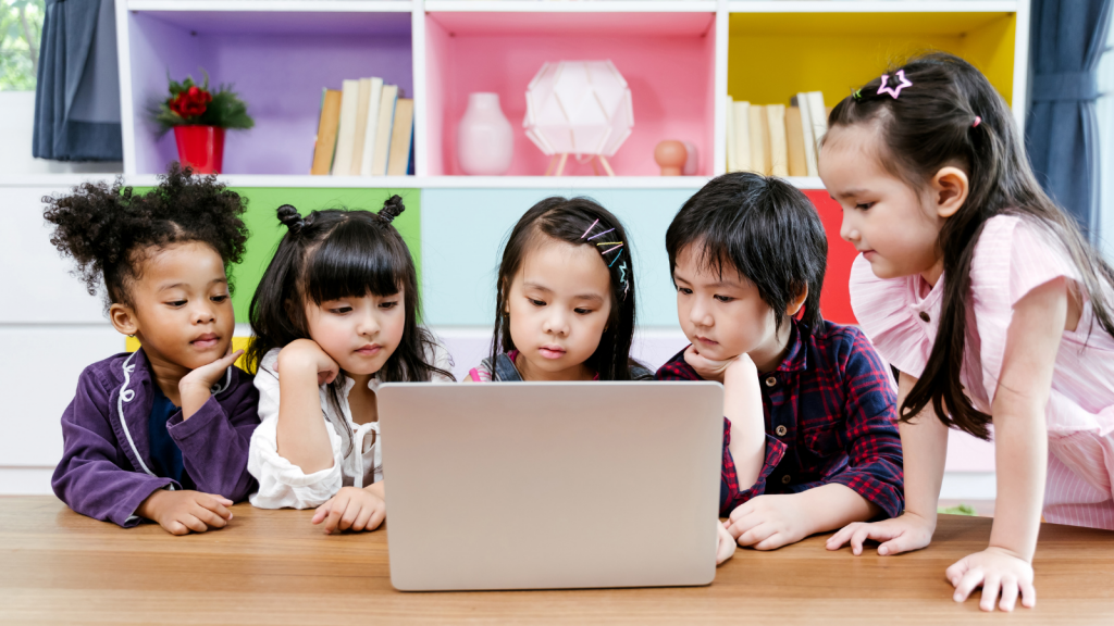 group of little children diversity watching film together on laptop. Kids playing with laptop computer at home