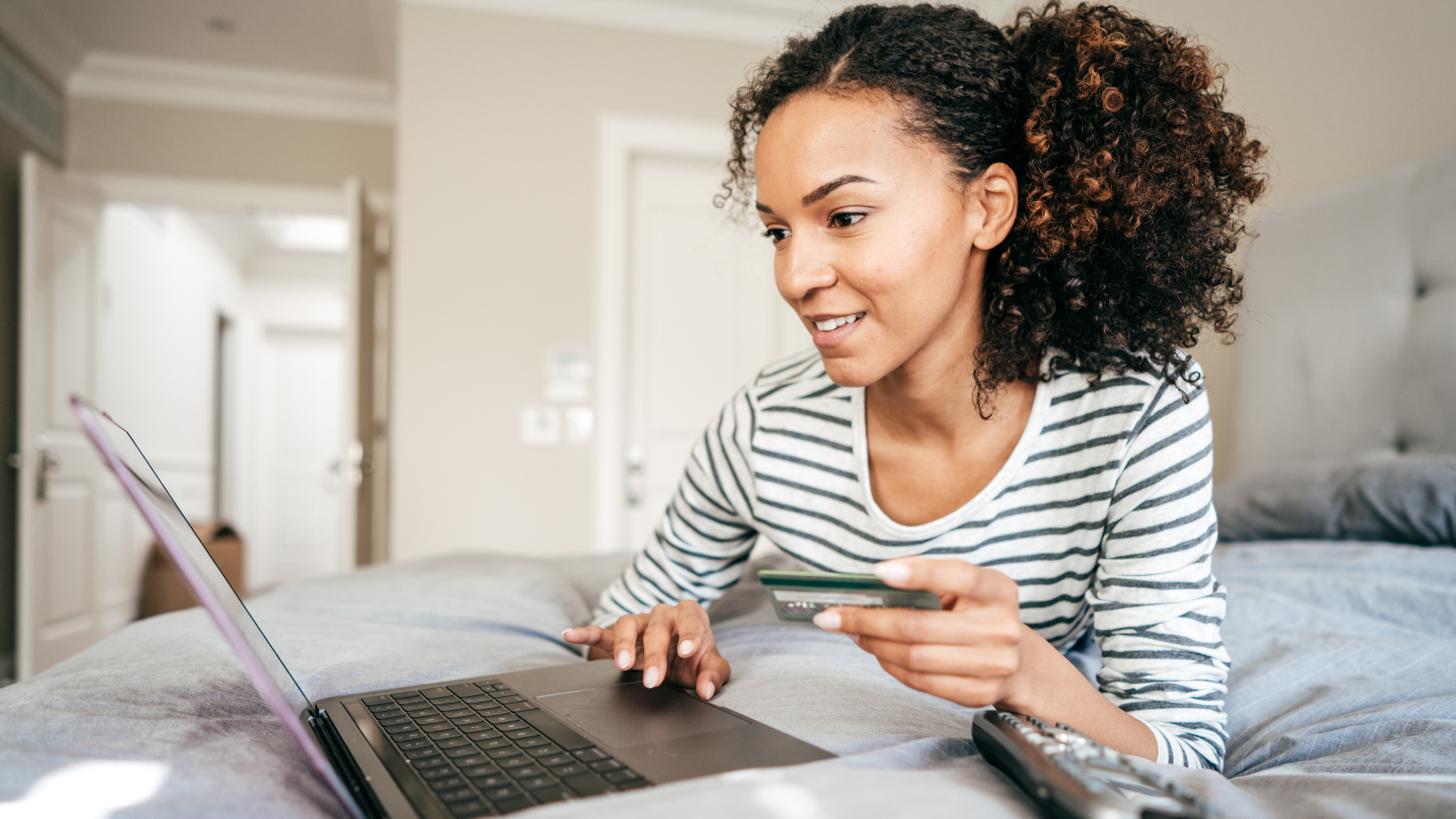 Woman making online payment in bed