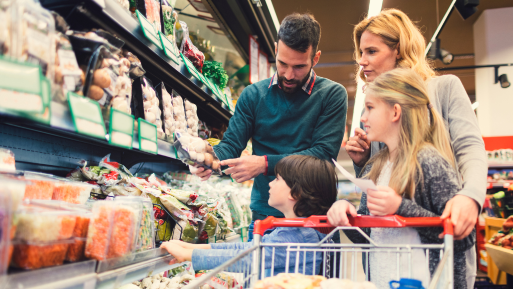 Two parents with their two children shopping in supermarket