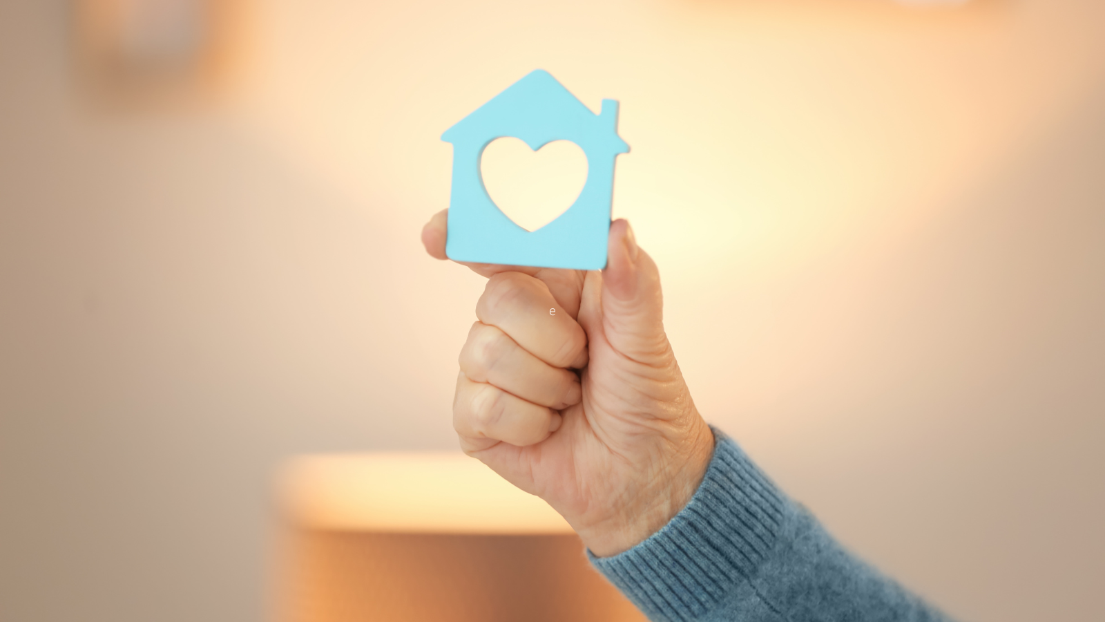 Hand Holding House-Figure on Blurred Background