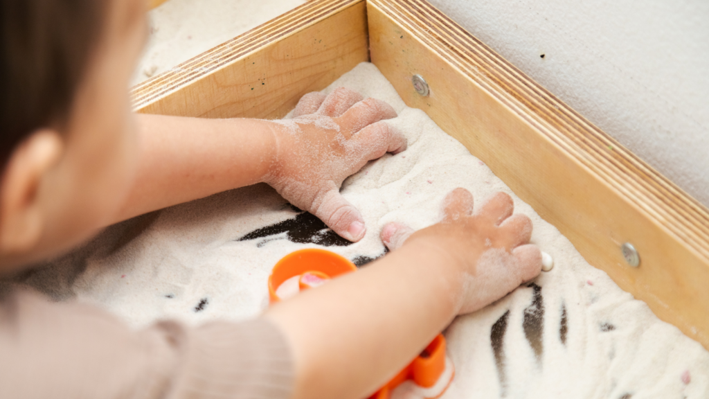 A toddler playing with sand.