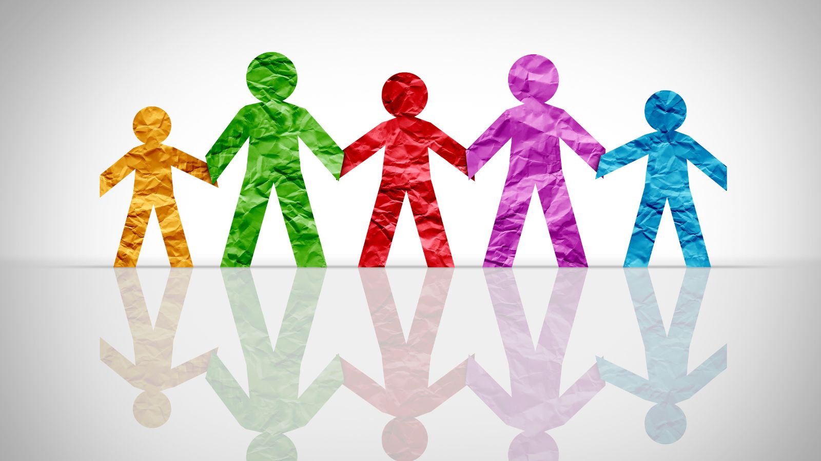 5 paper figures of different colours holding hands
